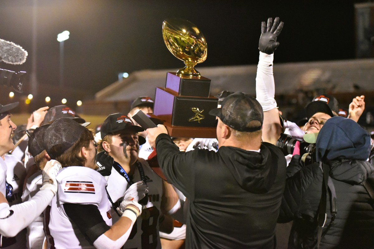 Washington players celebrate after being awarded the Class 2A state championship trophy on Dec. 9, 2023.